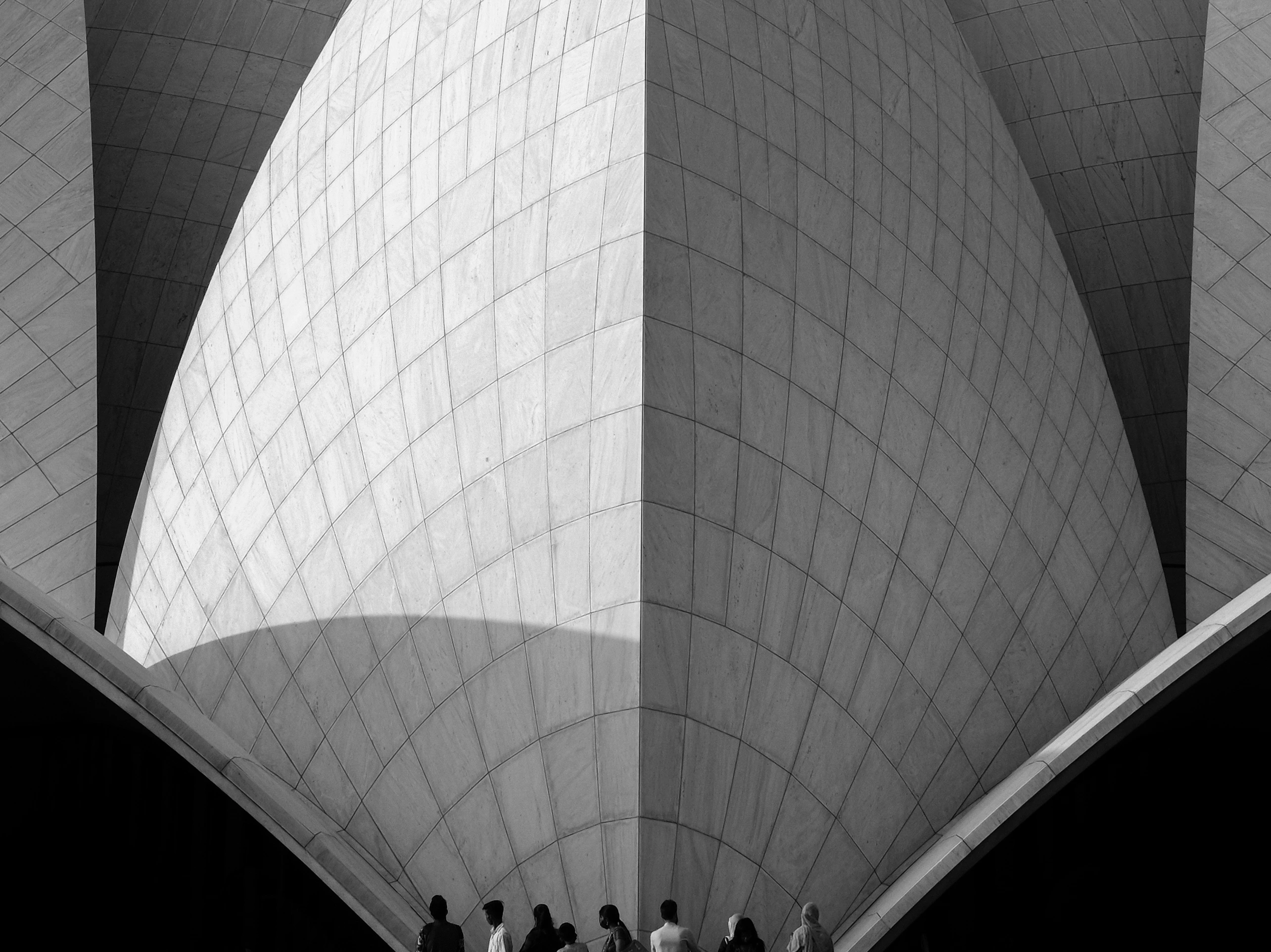 Monochrome architectural view of the Lotus Temple with visitors at its base.